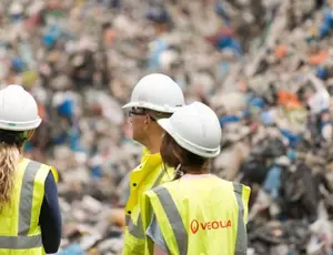 Collaborateurs Veolia devant un tas de déchets ménagers : site Veolia de Southwark au Royaume-Uni 